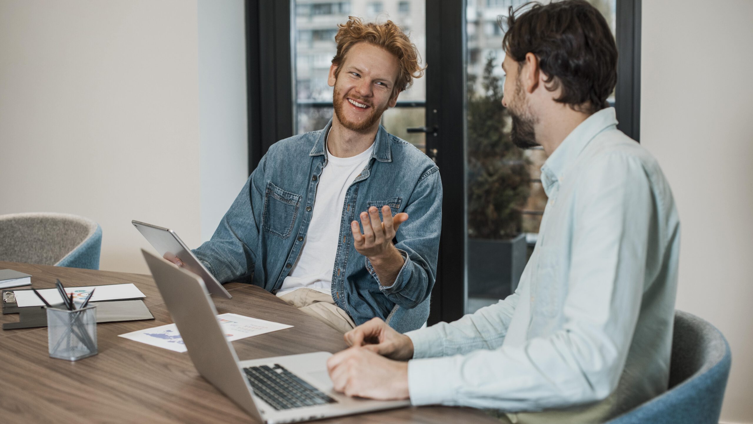 Zwei Kollegen unterhalten sich am Schreibtisch