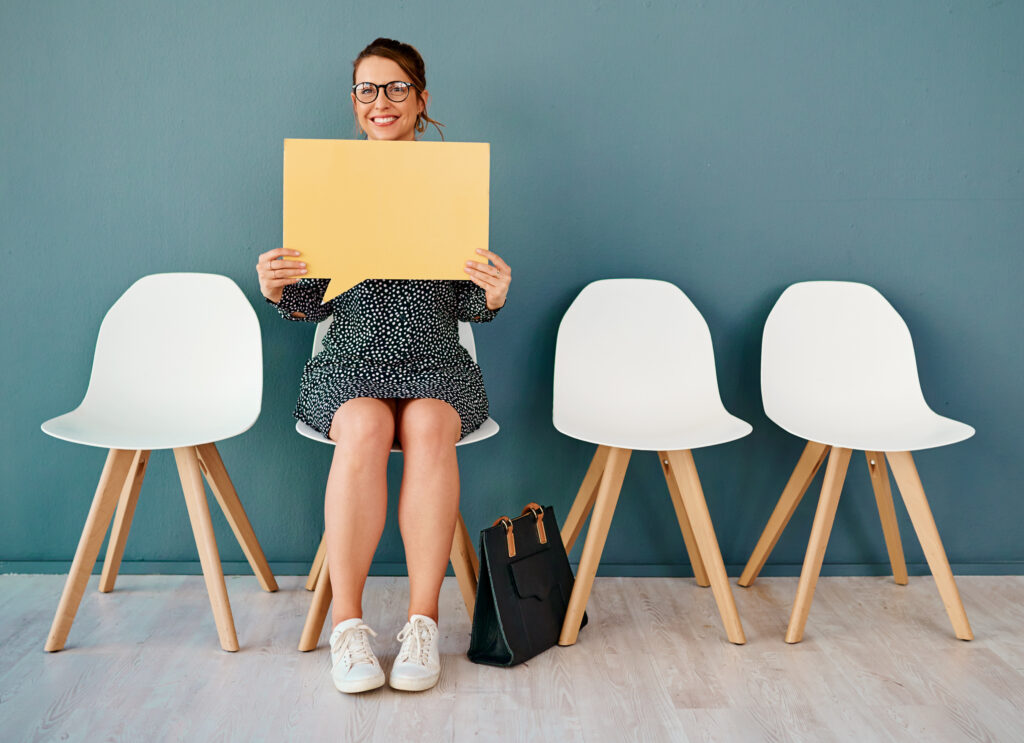 Bild für FAQs: Frau sitzt auf Bankreihen