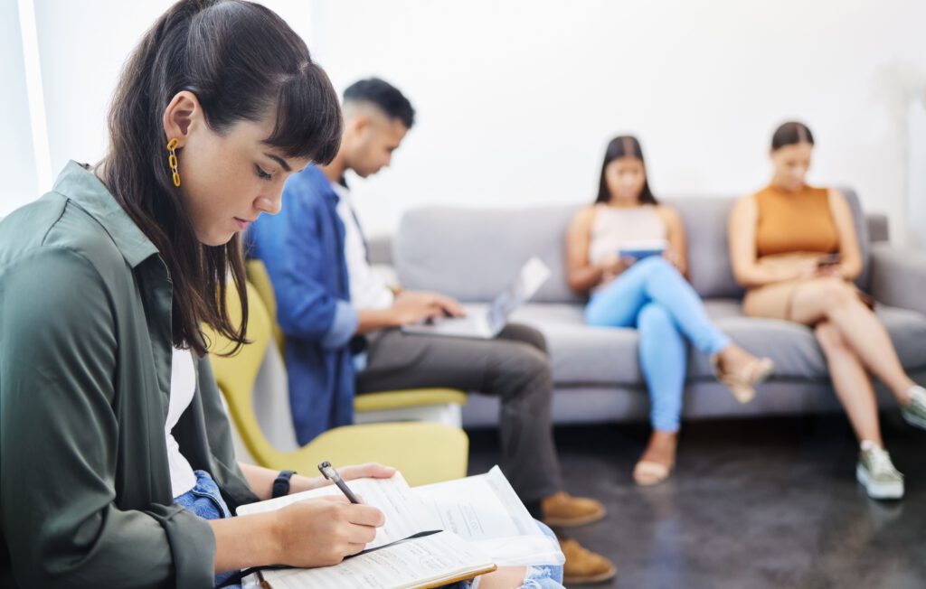 Junge Menschen auf einer Couch, füllen einen Lebenslauf aus